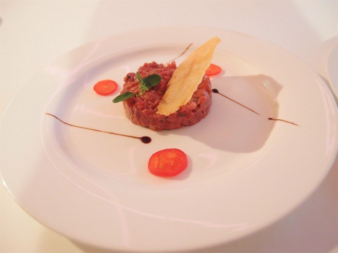 beef steak tartar with classic garnish and crispy potato