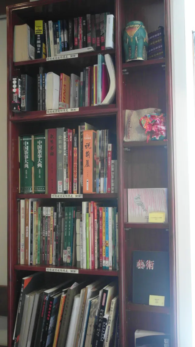 一壁牆上的小書架裡放了不少書刊