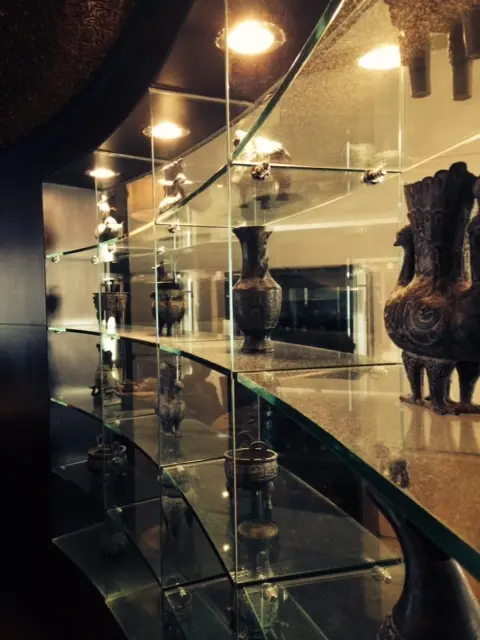 弧形的玻璃架上陳列了不少青銅器,每個的造型都不同