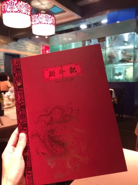 紅色餐牌上的熨金金龍圖案,有如一張喜帖