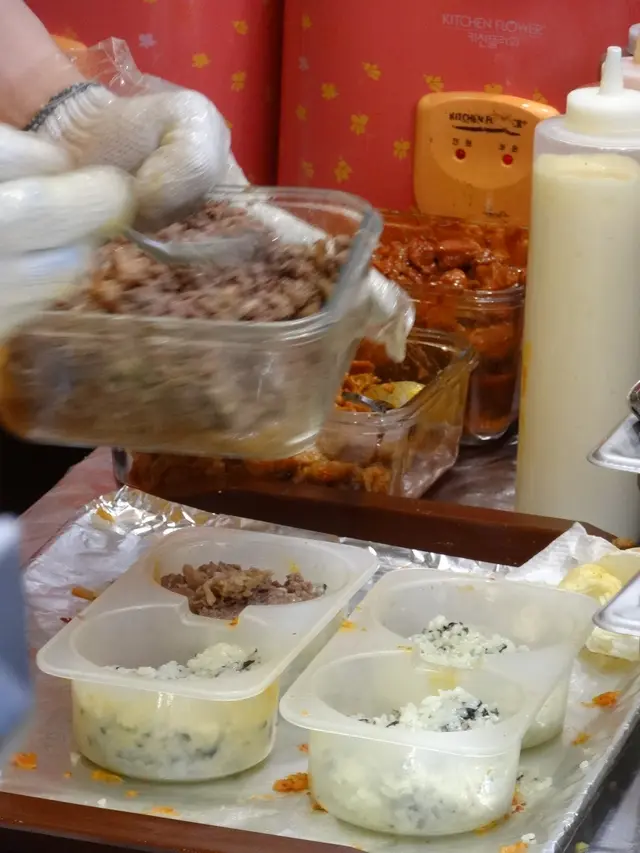 負責飯堡的韓籍男店員，戴上手套弄製飯堡，相當衛生！