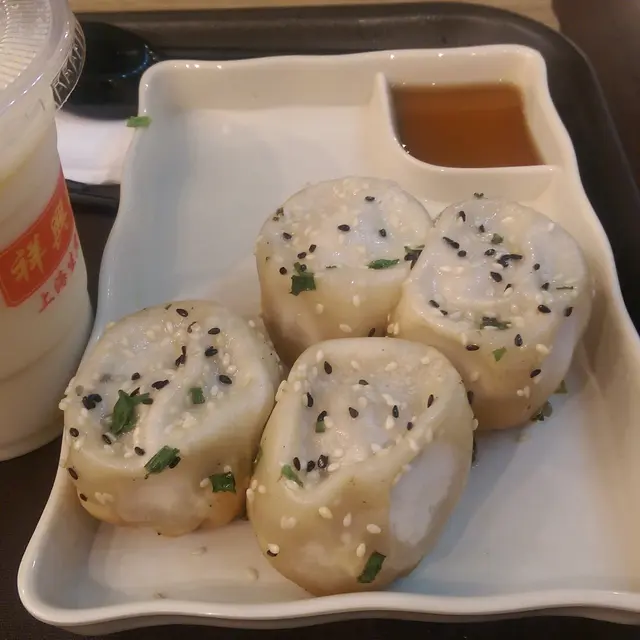 剛煎好的生煎包,脹卜卜,湯汁燙口。包底極為脆身,煎得金黃;包身則薄薄的,配以黑芝麻和蔥花,更為香口。