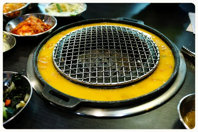 店員放入泡菜粒, 倒入蛋漿於爐邊慢慢煮熟, 這種食法新穎又有趣