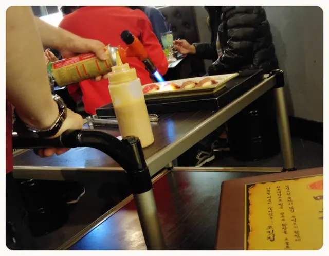 火灸霜降牛肉壽司, 店員即席表演用火槍, 將生牛肉的表面燒熟