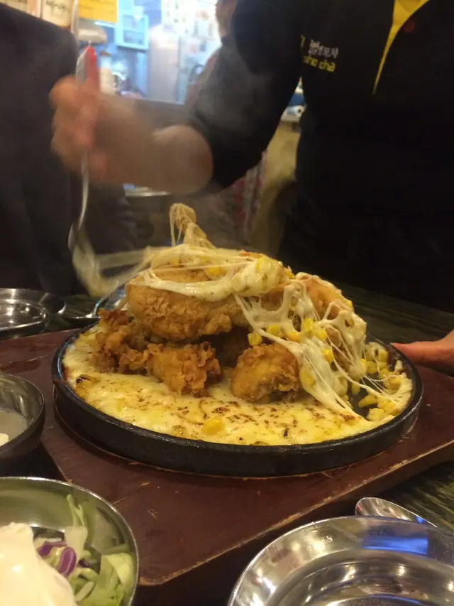 職員會為食客將芝士、粟米及雞件mix在一起。