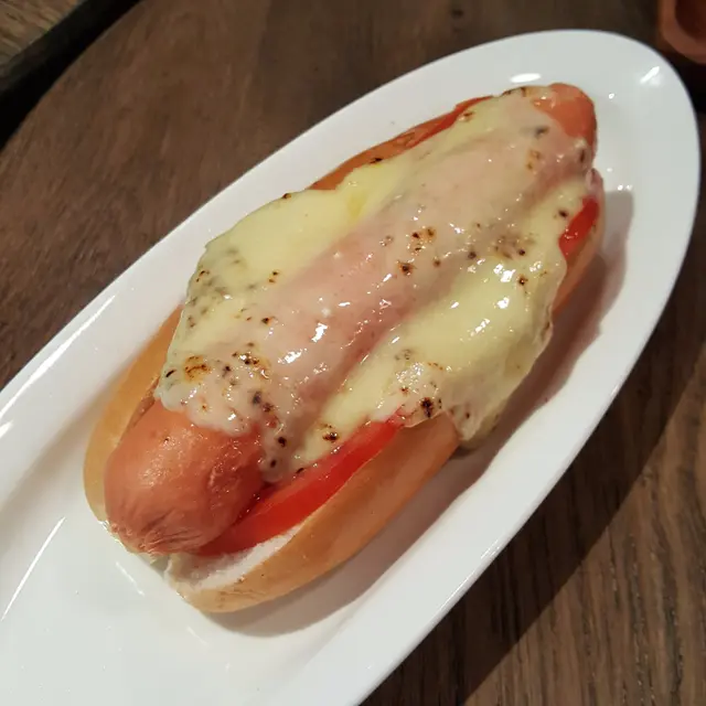 用熔化中的芝士加在熱狗上面,香腸下面加上茄汁,酸瓜汁和芥末,買相十分特別