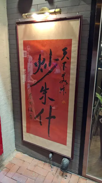 門口最吸引到每一個人眼睛就是一張由蔡瀾題字的『天下美味 炒豬什』毛筆字