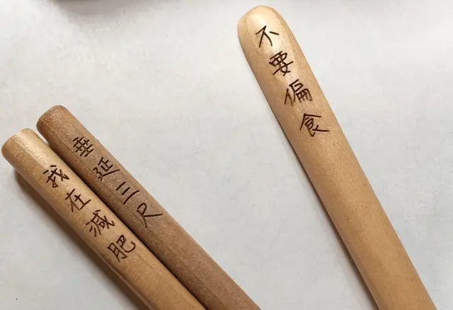 隨意拼湊成一對的筷子,碰巧是「不要浪費」及「大吃大喝」,有啲矛盾。