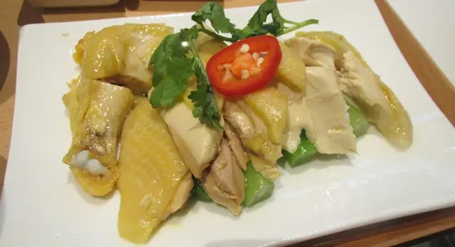 一大碟配有菜心的無骨雞肉