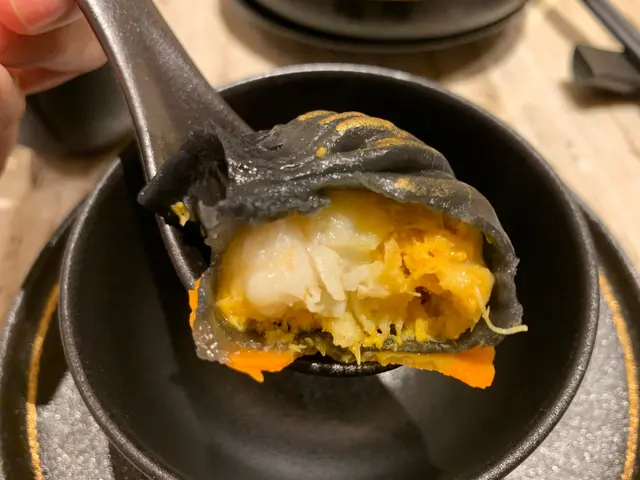 烏黑嘅墨汁皮，加上金箔嘅點綴，
咬開蝦餃，
就見到有好大隻鮮蝦肉同橙黃色嘅蟹粉係裏面，真係好真材實料呀！