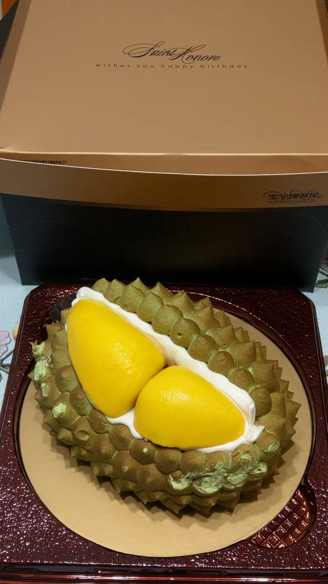 以金色盒蓋的深啡色紙蛋糕盒盛載