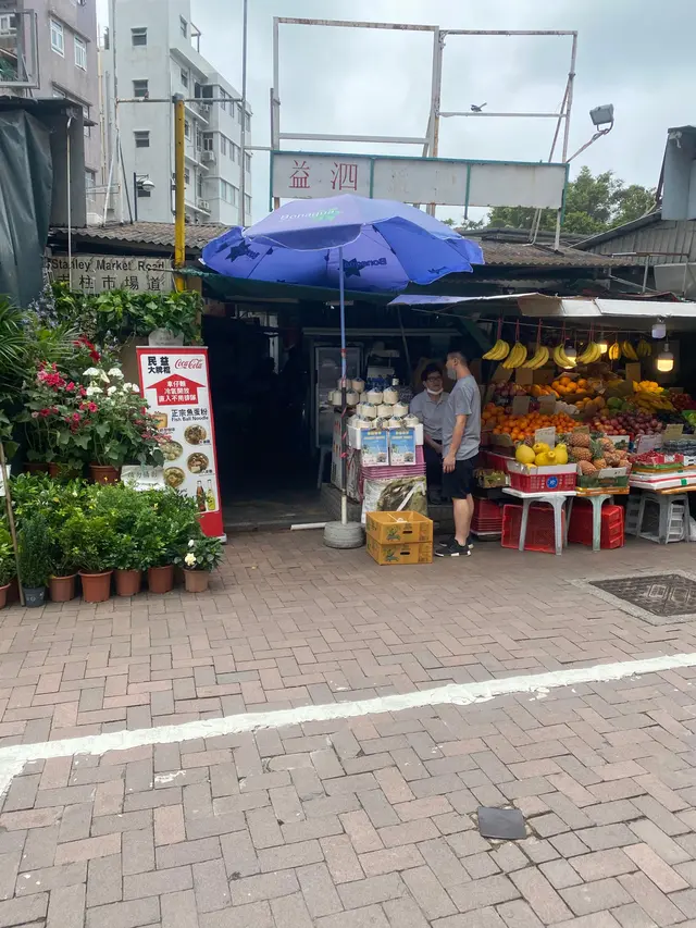 小店藏身喺赤柱市場道迴旋處旁既寮屋群入面,門口隔離有一個生果檔
