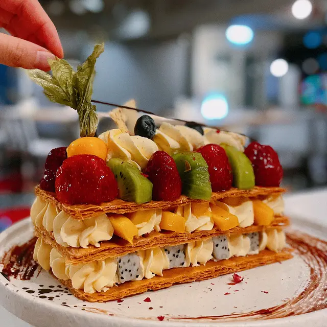 本身以為細細件，點知係原個上😳咁計返，$148又唔貴喎！賣相仲要咁靚靚，用嚟做節日蛋糕/生日蛋糕都得啦！🎂 拿破崙蛋糕內餡除咗有芒果🥭，仲有火龍果，切開會有清脆利落嘅酥脆聲，未食先流口水🤤