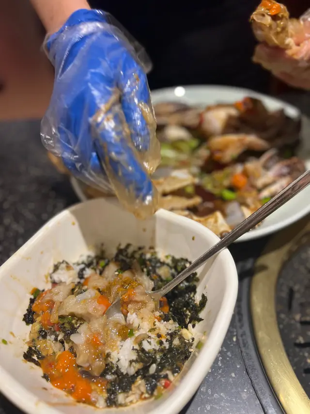 店員幫你將蟹肉蟹膏擠到紫菜飯