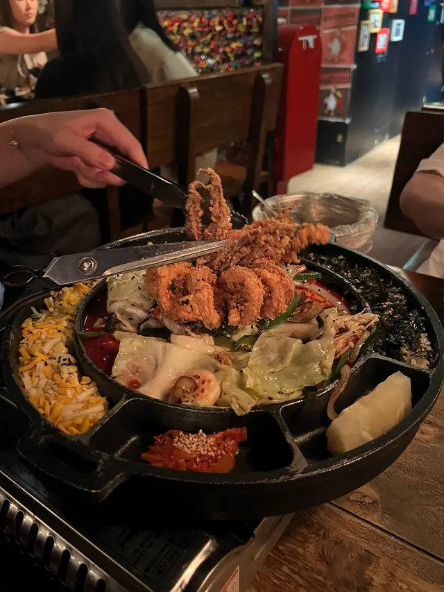 這是打卡之選吧～～～超大一個炸脆的魷魚🦑在上面
餐點來得會有店員幫忙剪開 份量好大呢～～～小鳥胃的二人肯定會吃不光
魷魚🦑下面 還有點別的海鮮 蛤蜊、蝦🦐 再加上一堆雜菜
怕辣的朋朋們要先夾沒沾到醬的部分 要不只能吃邊邊的起司🧀️、紫菜飯
因為他們的醬好有趣 第一☝️口 會覺得很正常 覺得可以吃
可是不用多久辣味就沖上來 好過癮（愛吃辣的朋朋們一定懂～哈哈哈
再加上起司🧀️ 又是另一種吃法 口感豐富 味蕾也非常刺激興奮😆