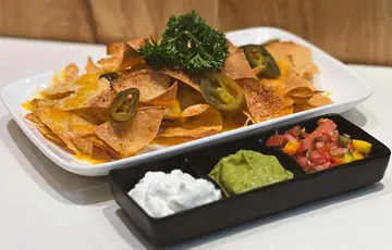 Hummus Signature Nachos Homemade tortilla chips, guacamole, sour cream and mango salsa
