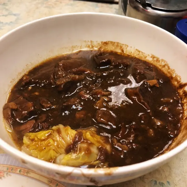 餐牌上有一個好醒目嘅菜式，叫做「終極牛腩」👀。想再嘅時候，係成碗牛腩上，入邊有菜膽，所有材料滲滿醬汁，成碗牛腩肉漆黑色。