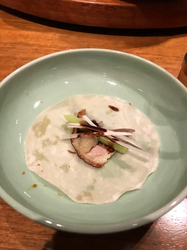 把填鴨用餃皮加葱、青瓜和醬汁,包成填鴨卷,好味!