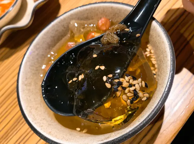 冰粉似是透明啫喱，口感嫩滑，
面頭撒上花生、黑白芝麻、山楂、酒釀、提子乾等，
拌勻後充滿咸香味又帶微甜，味道清新，
質感Q彈清爽，口感極佳富層次，解辣一流！
