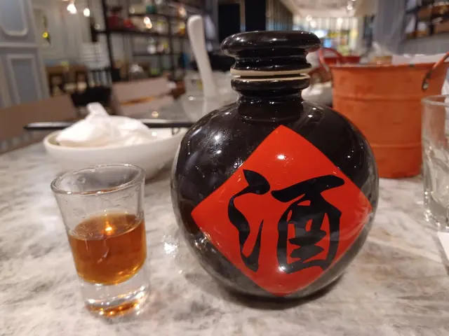 我見到人地桌上有一個空樽。原來係黑糯米酒。職員俾咗一個小量俾我試飲。飲完好重黑糯米味。酒精達55%。微辣。建議同乳鴿食。最後我買咗個$158，500ml黑糯米酒外賣。